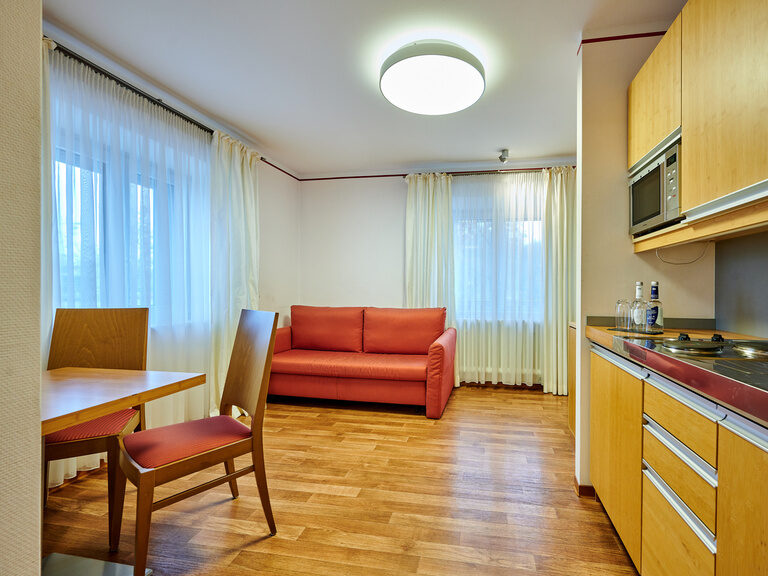 Ein rotes Sofa in einem gemütlichen Wohnzimmer des Gästehaus Wenisch.