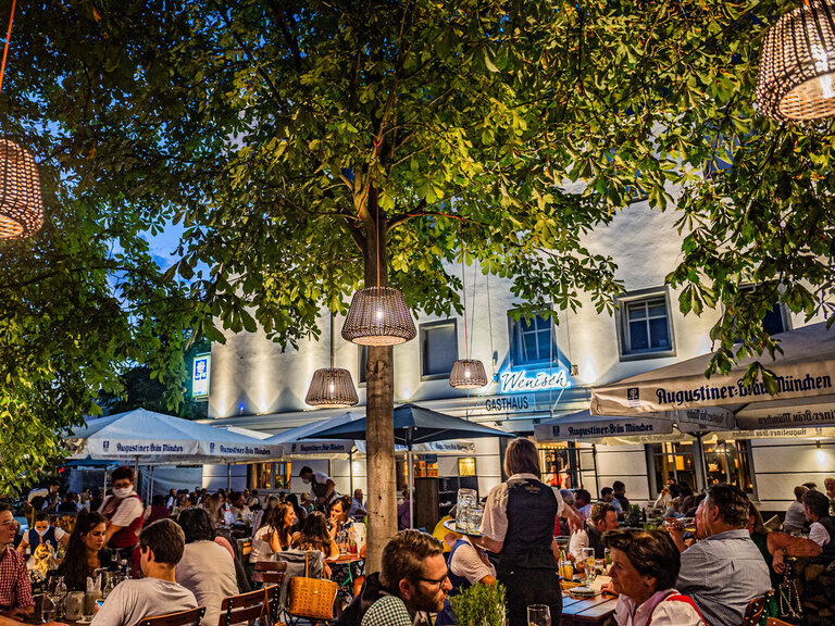 Eine Gruppe von Personen sitzt an Tischen im Biergarten des Toni´s Gasthaus in Straubing.