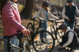 Mehrere Kinder mit Fahrradhelmen stehen mit ihren Fahrrädern auf einem Weg im Freien