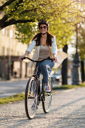 Eine Frau fährt mit einem Fahrrad einen Weg in Straubing entlang.