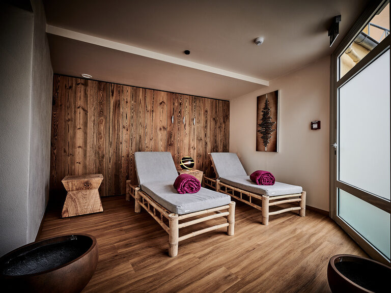 Zwei nebeneinander stehende Liegen im im Holzdesign gehaltenen Ruheraum in der Genussspa im Hotel Wenisch.