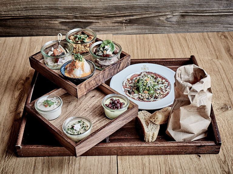 Ein hölzernes Tablett mit einem köstlichen Frühstück im Genusshotel Wenisch.