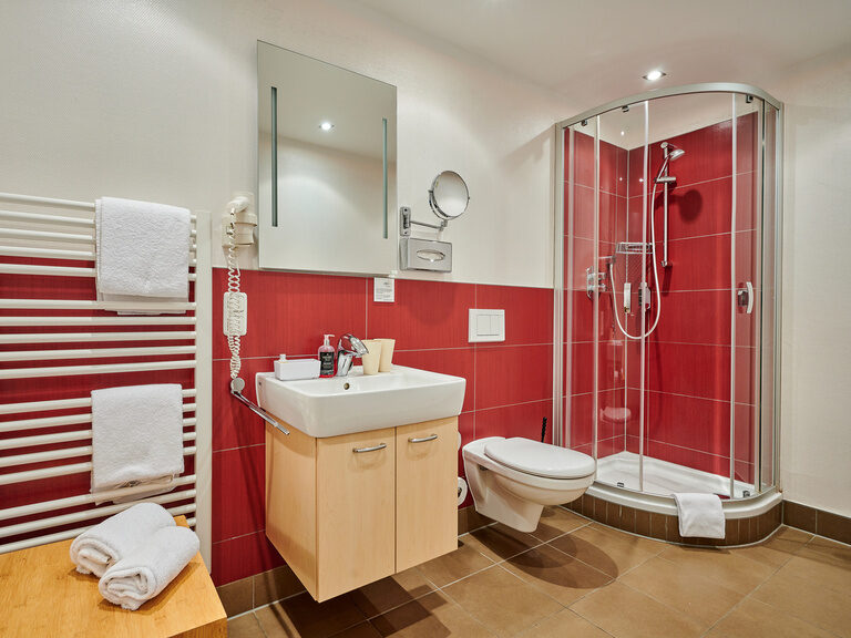 Ein stilvolles Badezimmer mit roten Wänden im Apartment Gästehaus Wenisch.
