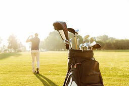 Ein Mann spielt Golf auf dem grünen Rasen des Golfplatzes.